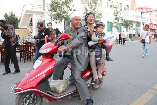 Uighur family on a scooter 