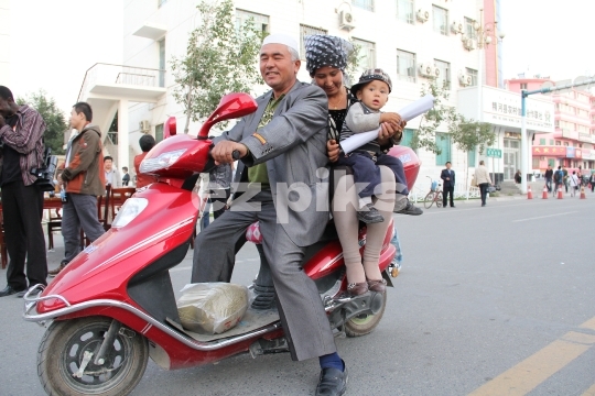 Uighur family on a scooter 