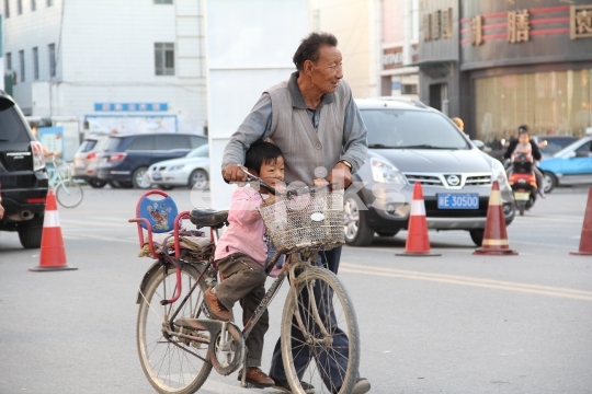 Xinjiang man pushing a bike 